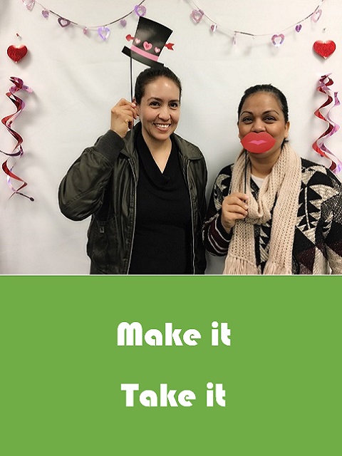 Some family members attending the Make-it Take-it are posing for pictures with prop hats and smiles on a stick